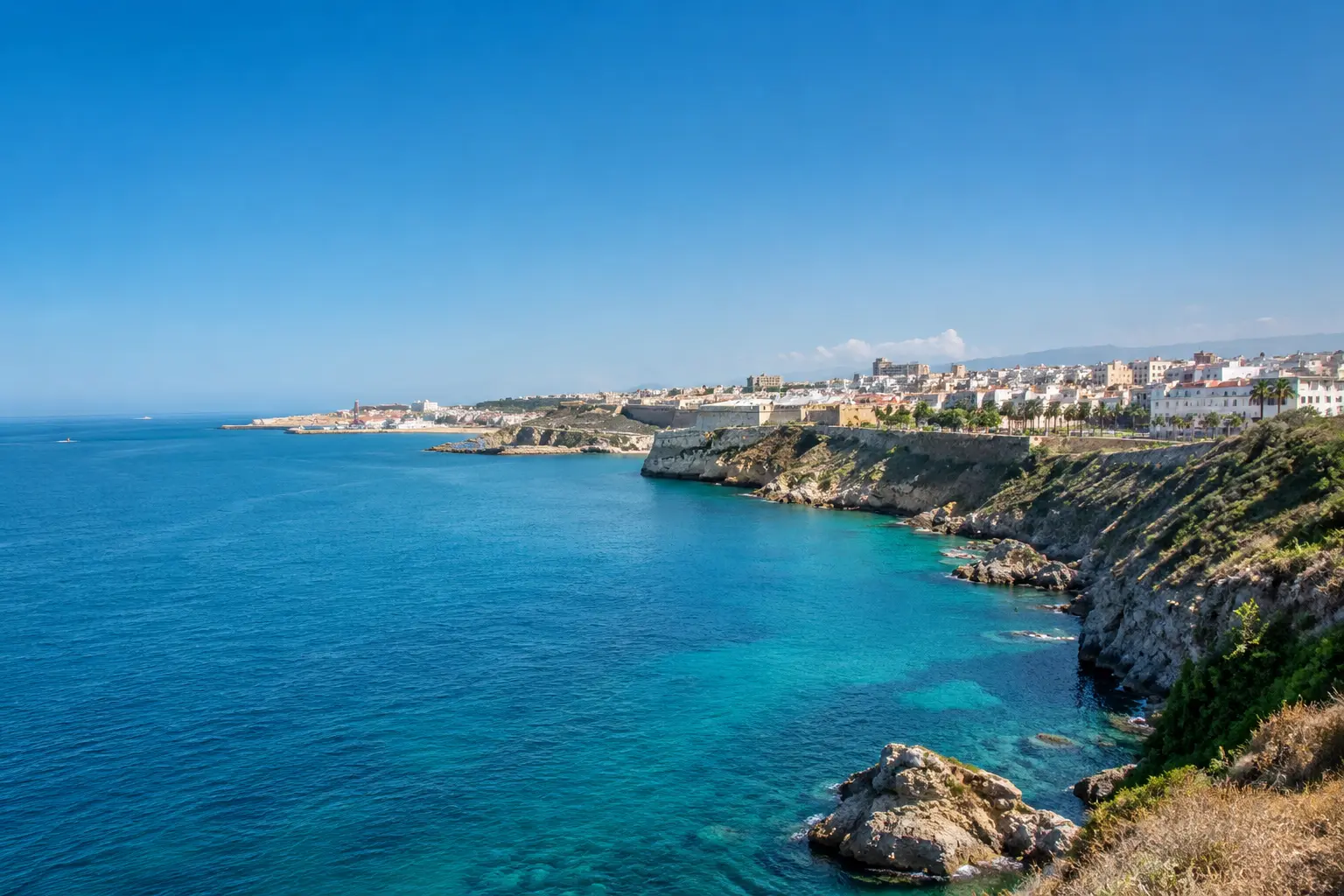 Panoramic view of Ceuta Spain's coastal cliffs and turquoise Mediterranean waters along the North African coast.